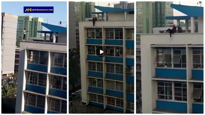 Young man pulling dangerous stunts on high building